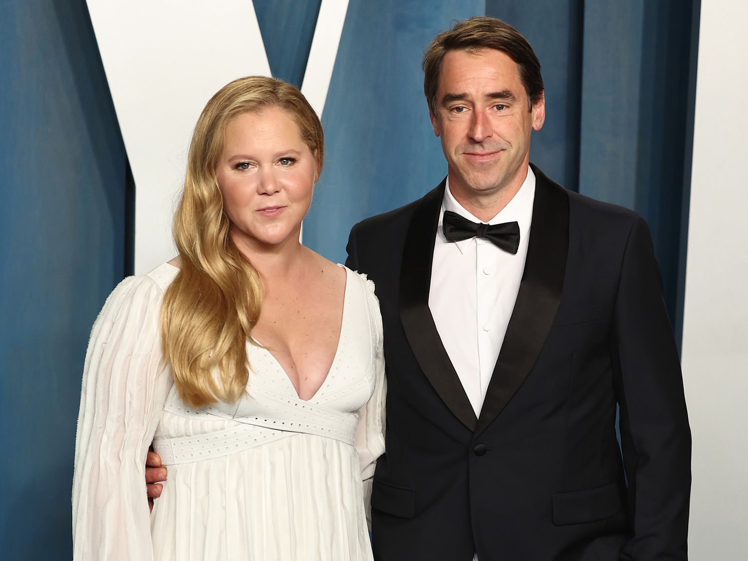 Amy Schumer and Chris Fischer pose together on the red carpet, smiling for photographers during a high-profile event, before their reported separation.