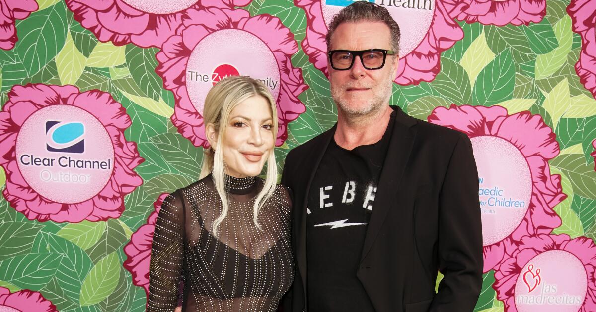 Tori Spelling and Dean McDermott posing together on the red carpet, smiling for cameras while dressed in formal attire at a Hollywood event.