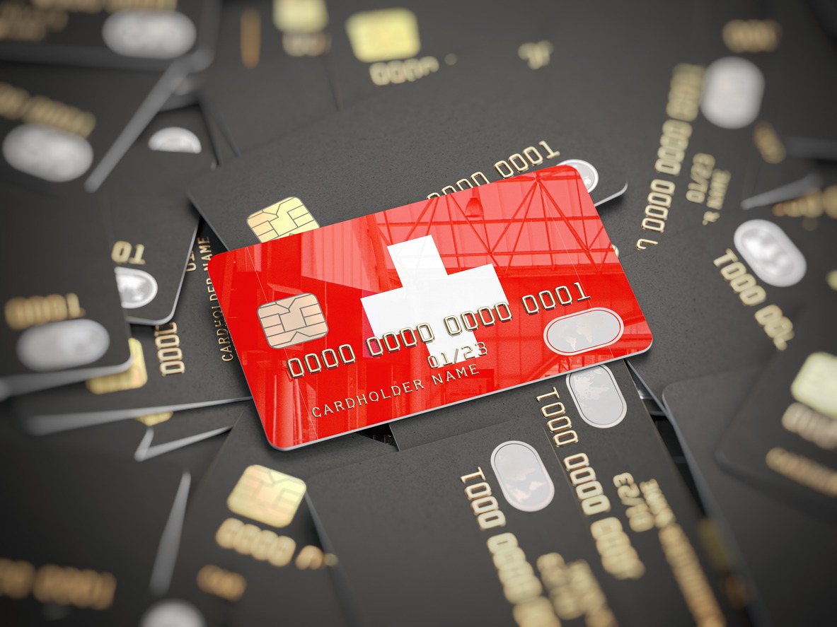 credit card of swiss bank on the heap of other different black cards. opening a bank account in switzerland.