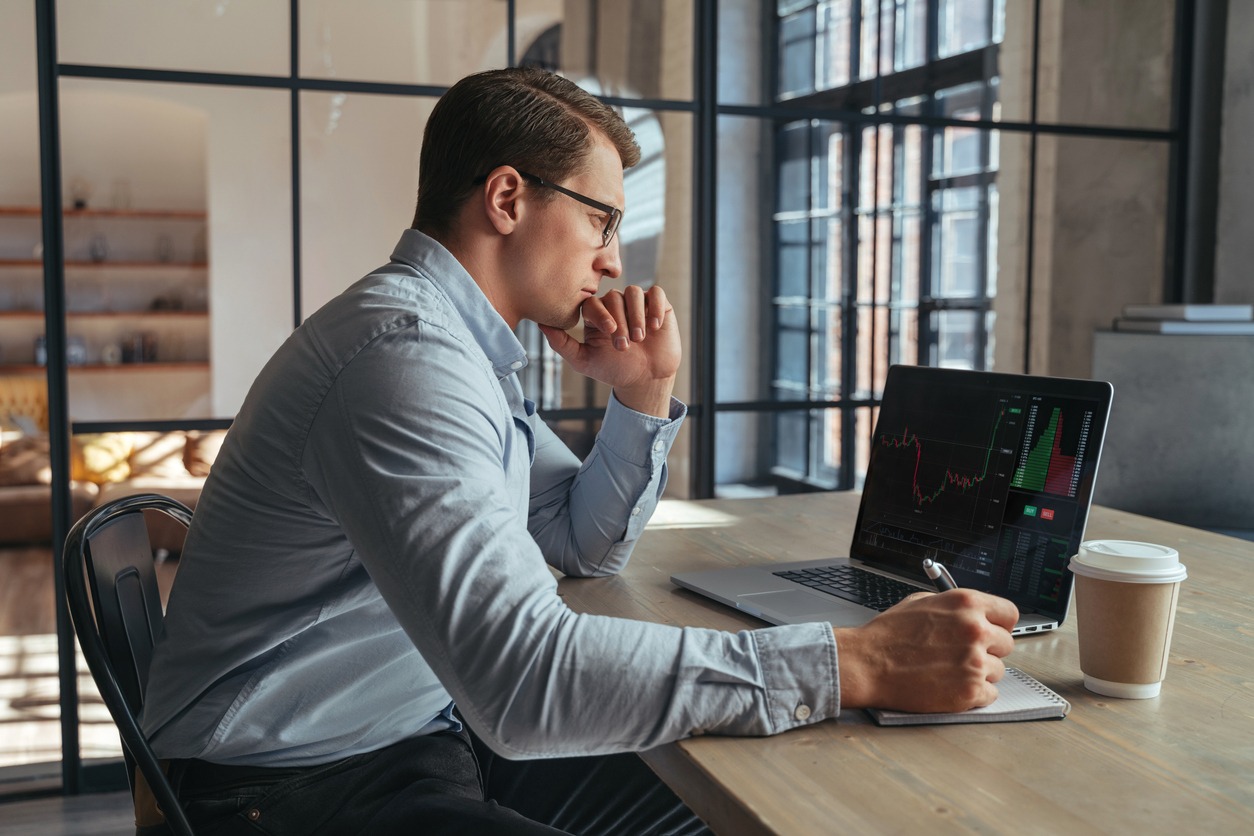 serious crypto trader analyzing risks of buying cryptocurrency in global recession looking at chart