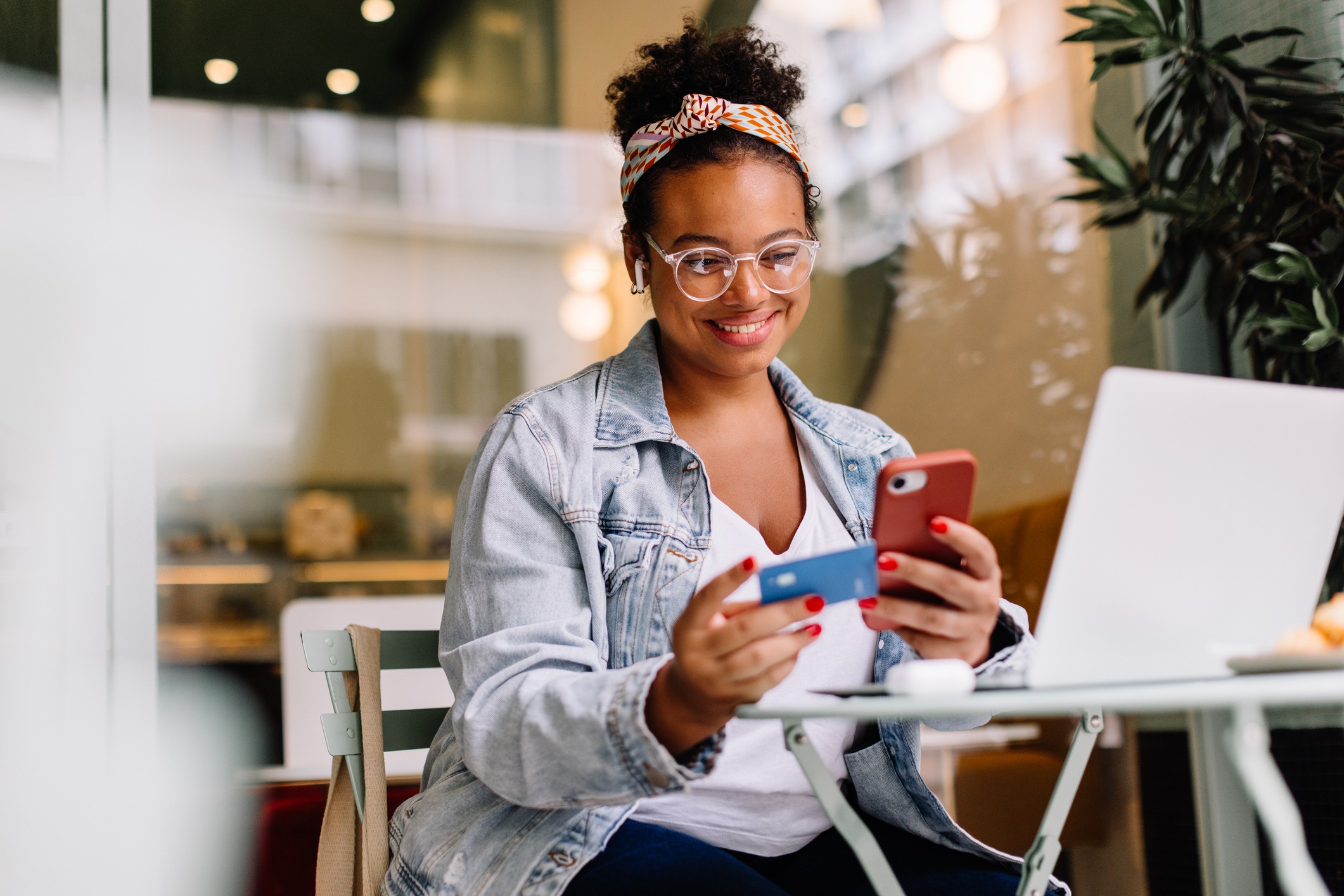 woman smiling and using mobile for online payment
