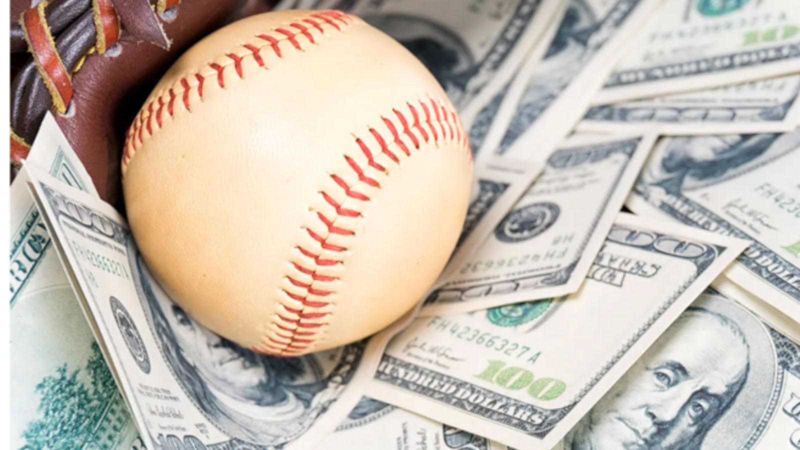A baseball resting on a stack of U.S. dollar bills, symbolizing the massive financial value of Major League Baseball’s new broadcast and streaming agreements.