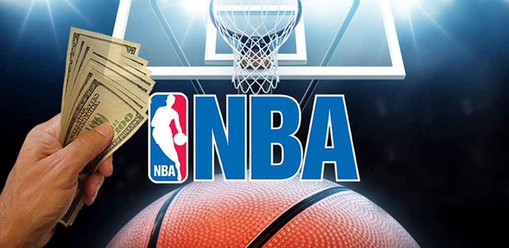 “The NBA logo in the background with a basketball hoop and a hand holding cash in the foreground, symbolizing the connection between basketball and betting.