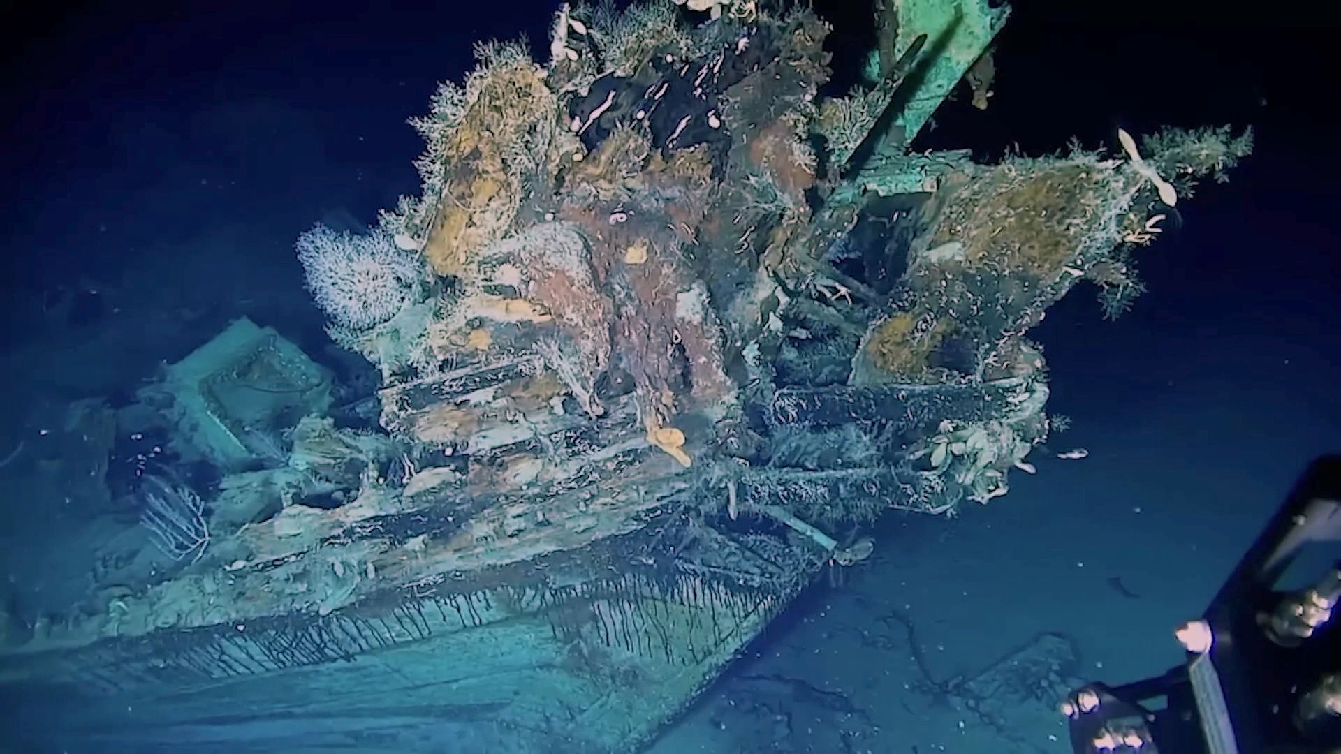 “Underwater view of the San José shipwreck resting on the seafloor, with coral-covered debris and fragments of the centuries-old galleon visible.