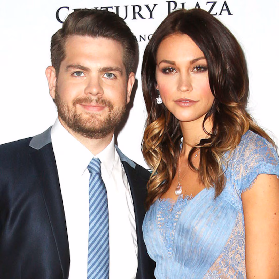 Jack Osbourne and his wife smiling together on the red carpet.