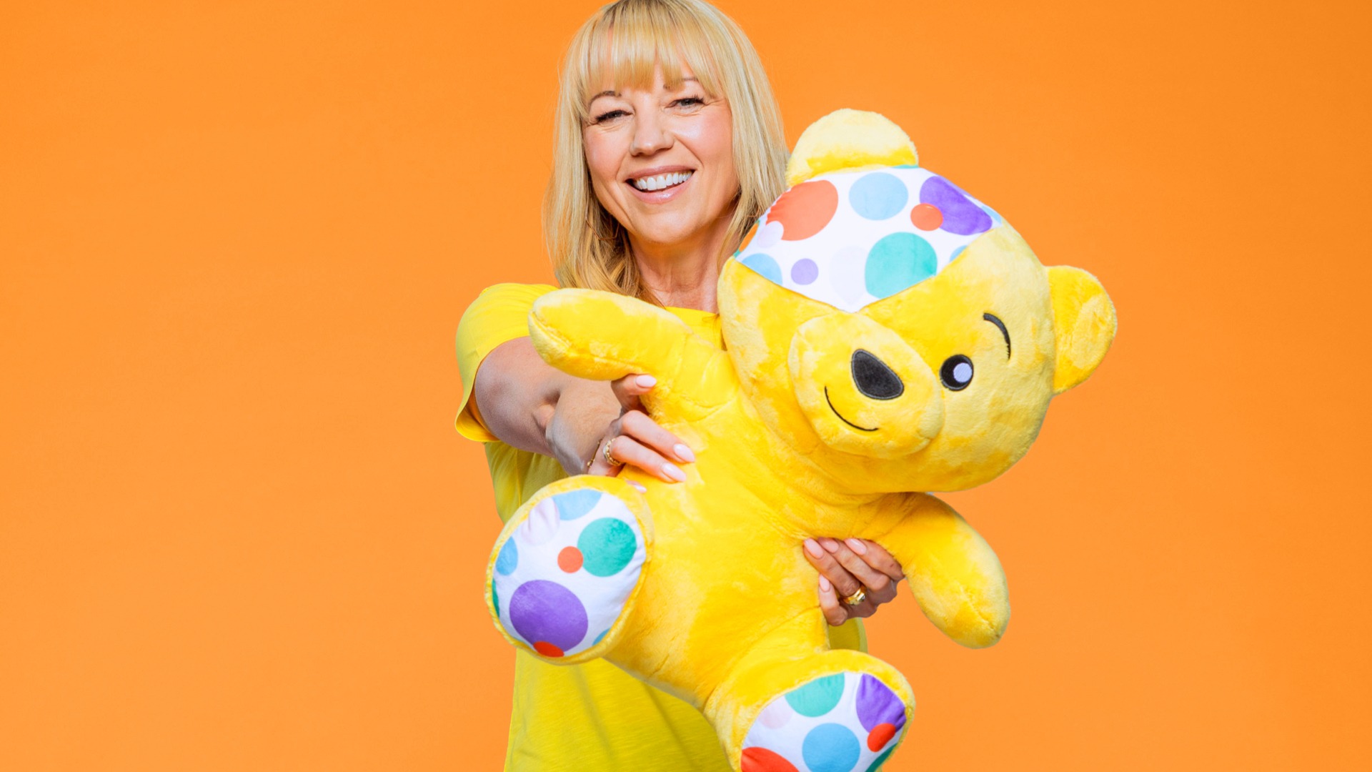 Sara Cox holding a Pudsey Bear teddy as she prepares to start her 135‑mile Great Northern Marathon Challenge for Children in Need.