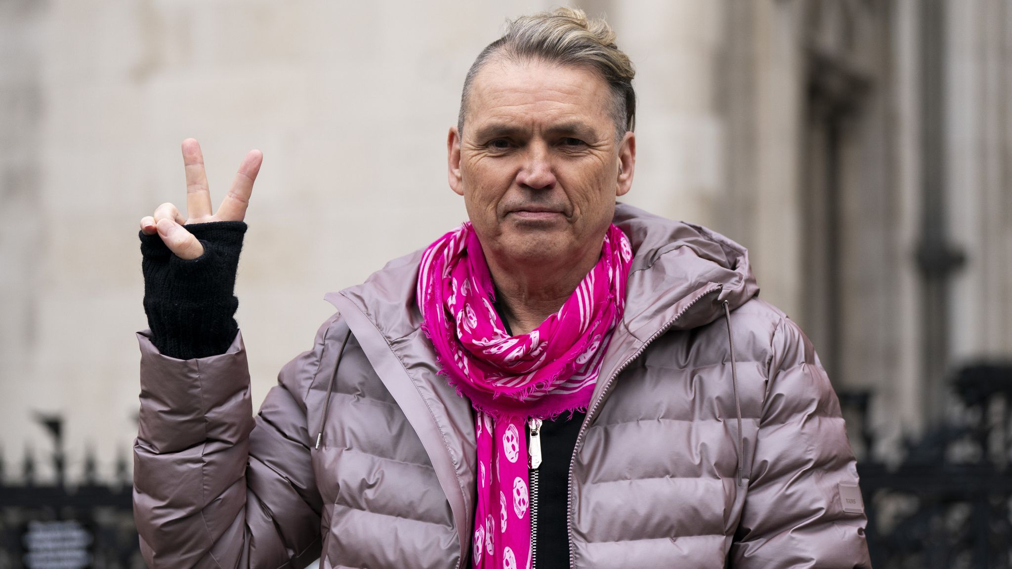 Dale Vince flashing a peace sign, co-founder of Ecotricity and member of Patriotic Millionaires UK, advocating for higher taxes on the ultra-wealthy to support public services.