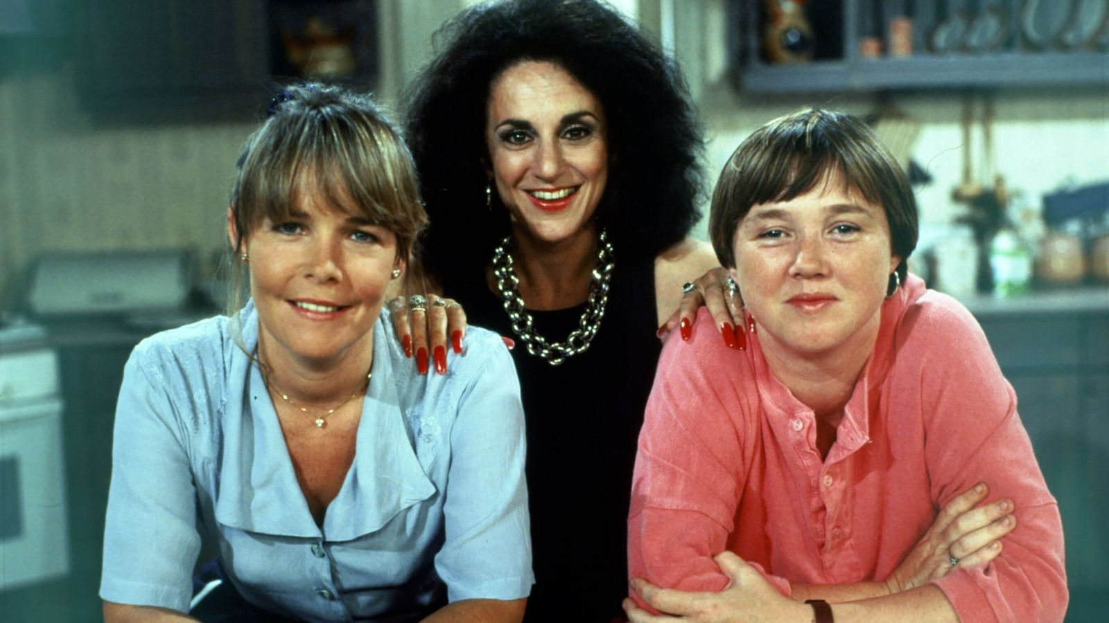 Pauline Quirke standing alongside her two co-stars on the set of Birds of a Feather, all smiling between takes.