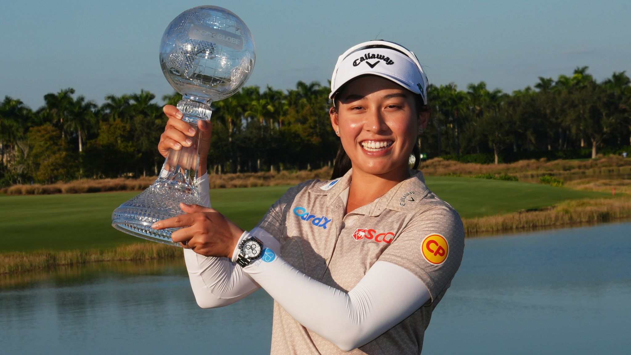 Jeeno Thitikul smiling and holding the CME Group Tour Championship trophy after her historic LPGA win.