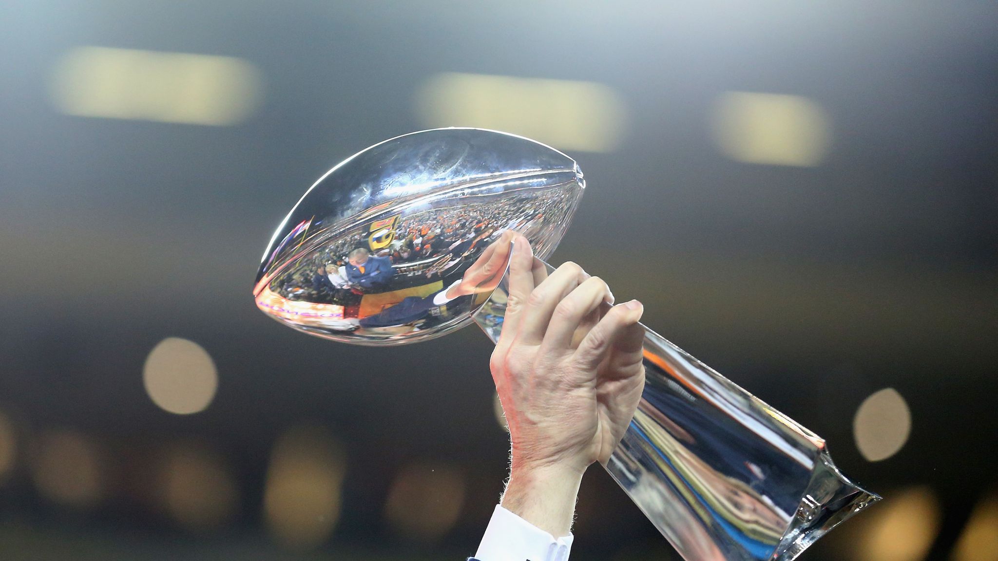 The Vince Lombardi Super Bowl trophy on display, gleaming under bright lights, symbolizing Bad Bunny’s upcoming halftime performance.