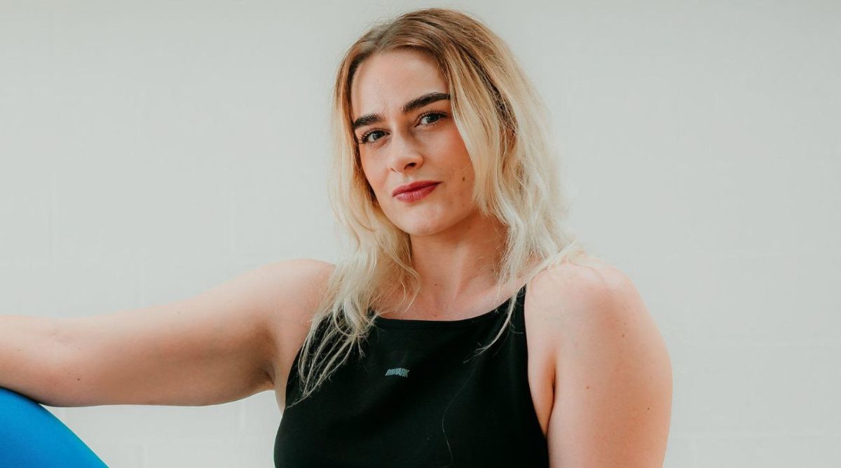 Georgina Cox posing confidently in gym gear for Sports Illustrated, promoting body positivity and fitness empowerment.