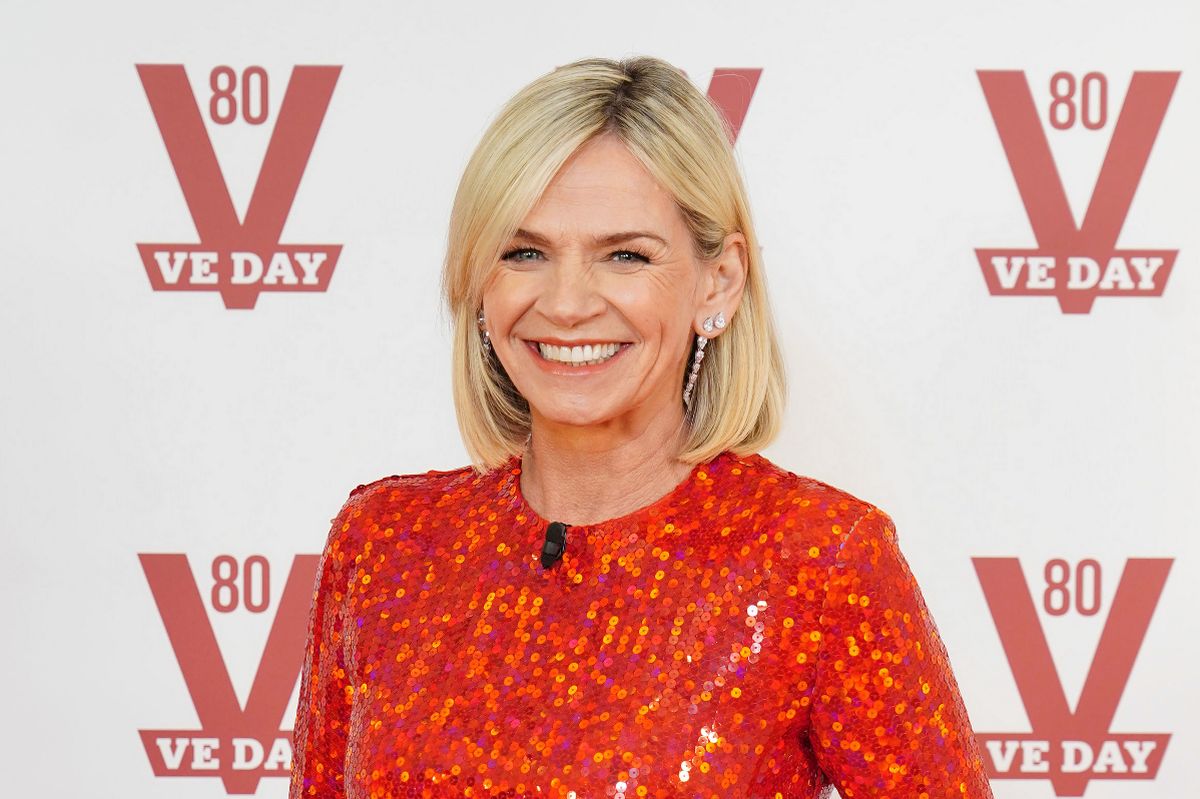Zoe Ball smiling on the red carpet at a public event, wearing an elegant outfit and posing confidently for photographers