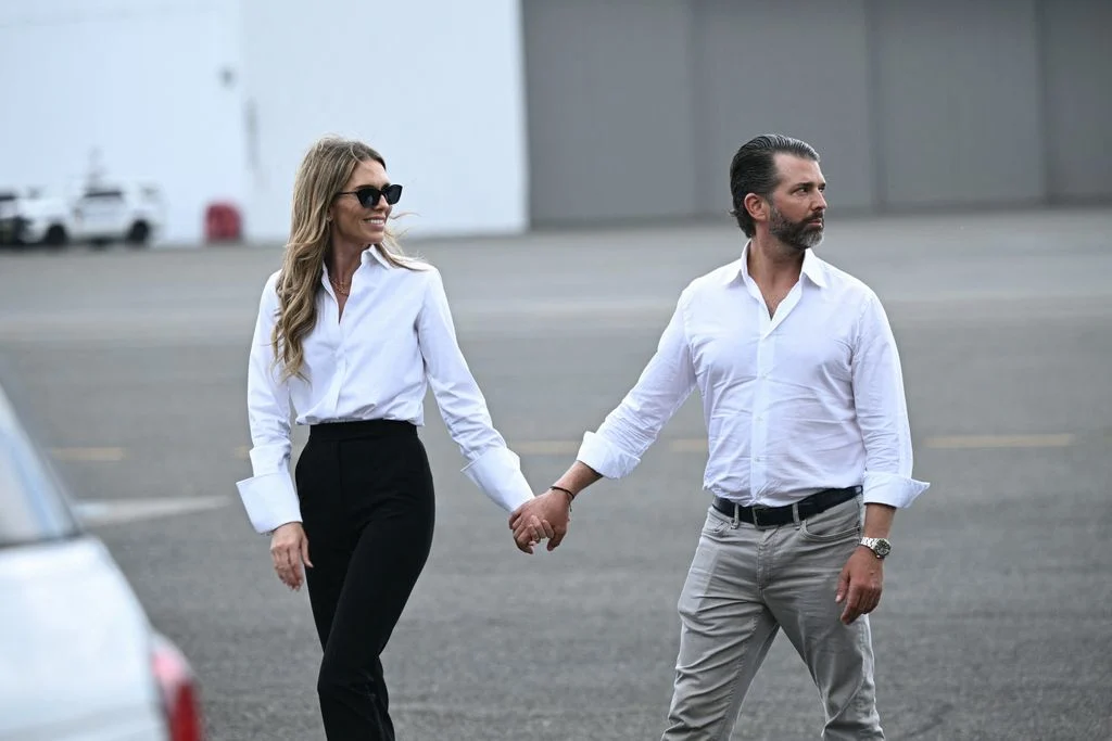 Donald Trump Jr. and Bettina Anderson hold hands as they exit Air Force One after their engagement announcement.