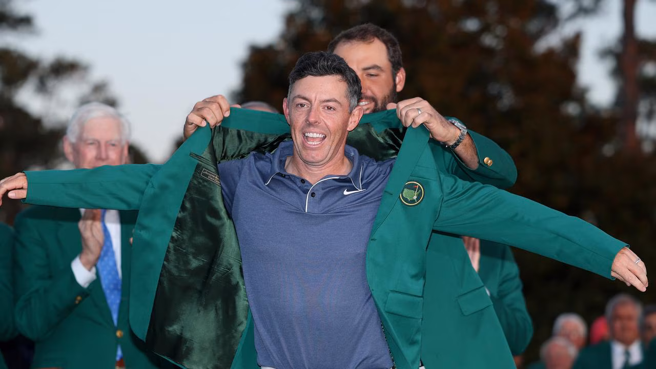 Rory McIlroy wearing the iconic green Masters jacket, smiling with quiet pride after finally completing the career Grand Slam.