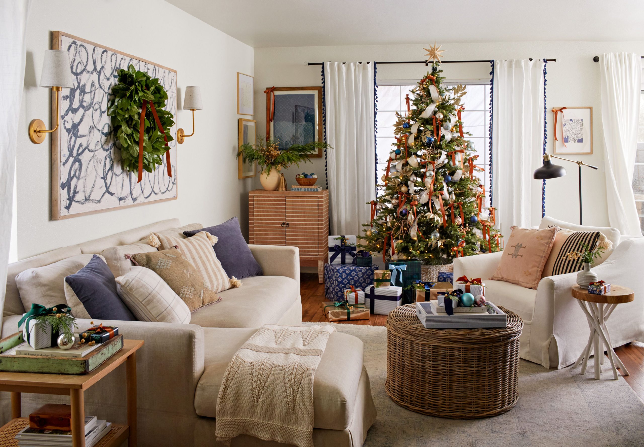 A warm and inviting living room decorated for Christmas, featuring a homely tree with soft lights and a festive wreath hanging on the wall.