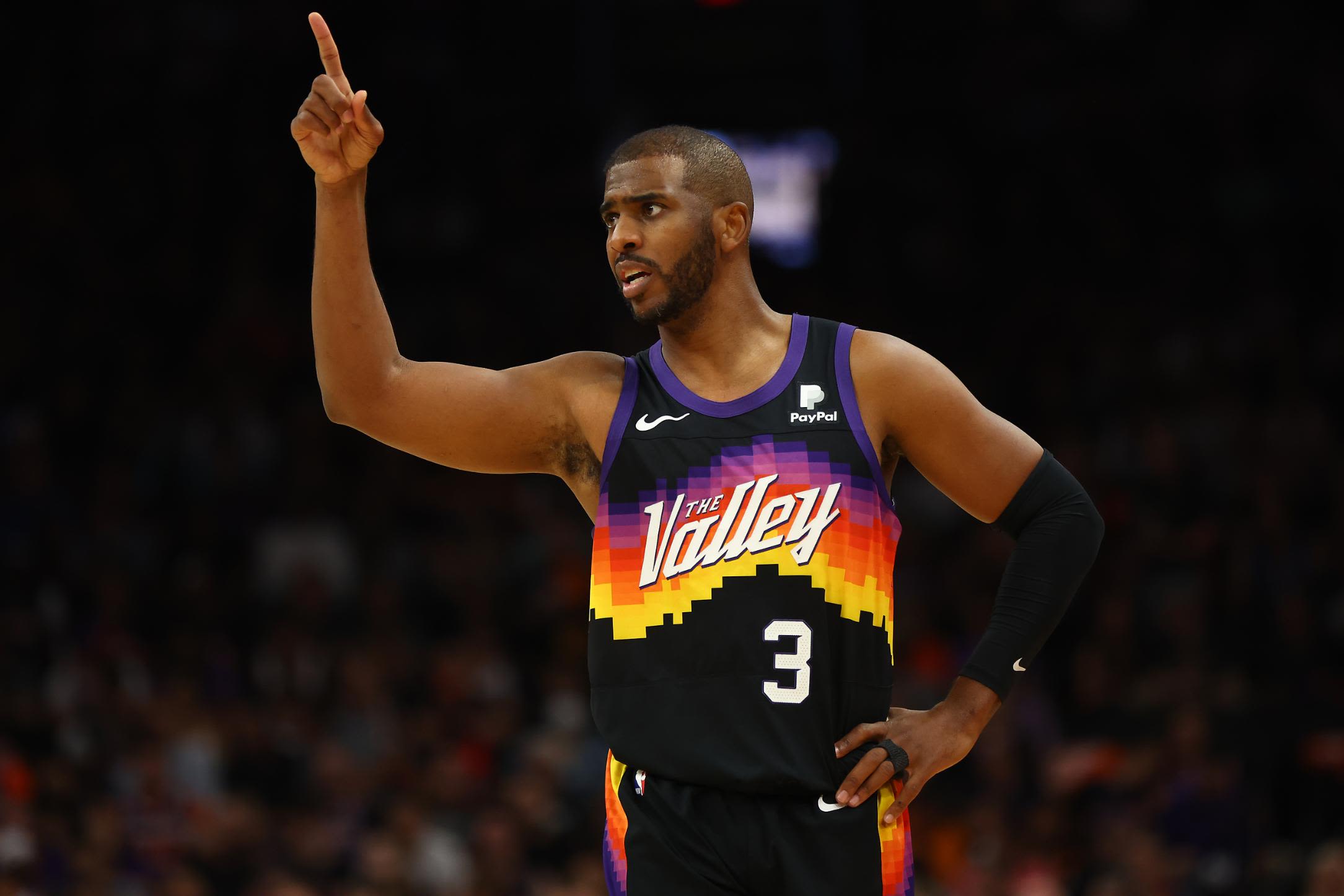 Chris Paul handling the ball on the court while playing for the Phoenix Suns, showcasing his veteran leadership and court vision.