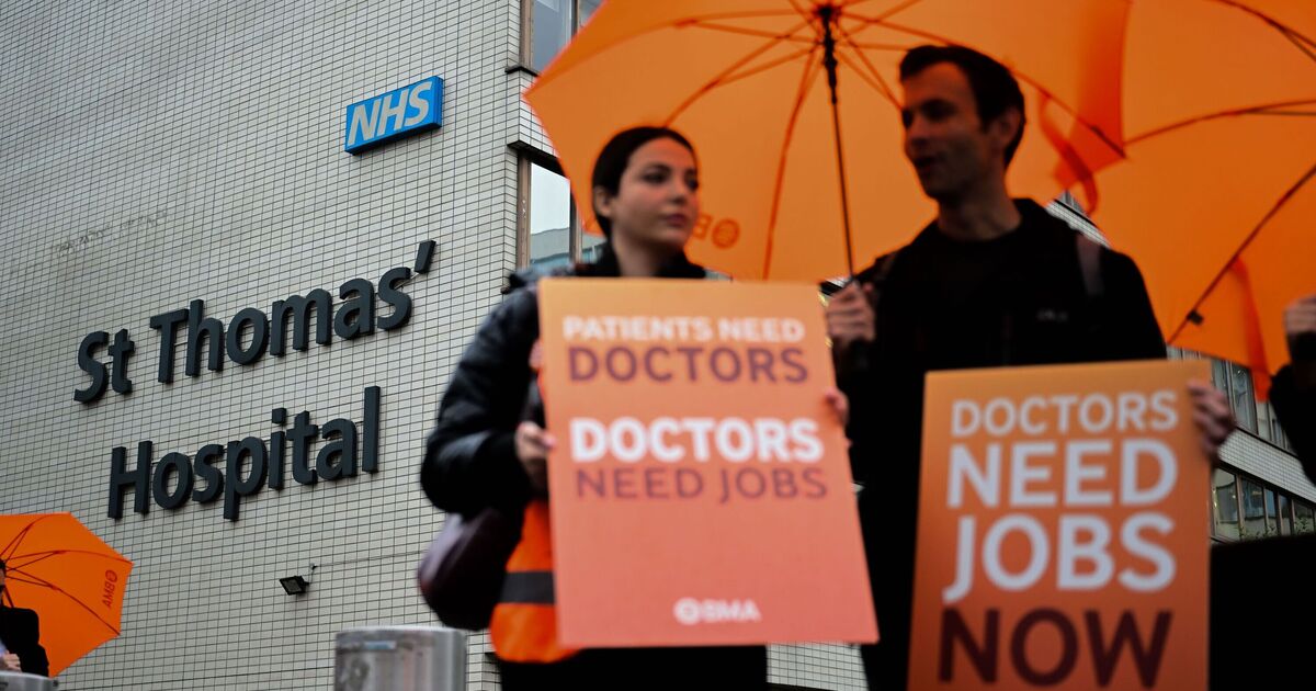 Resident doctors striking outside St Thomas’ Hospital in London, holding placards and demonstrating for higher pay.