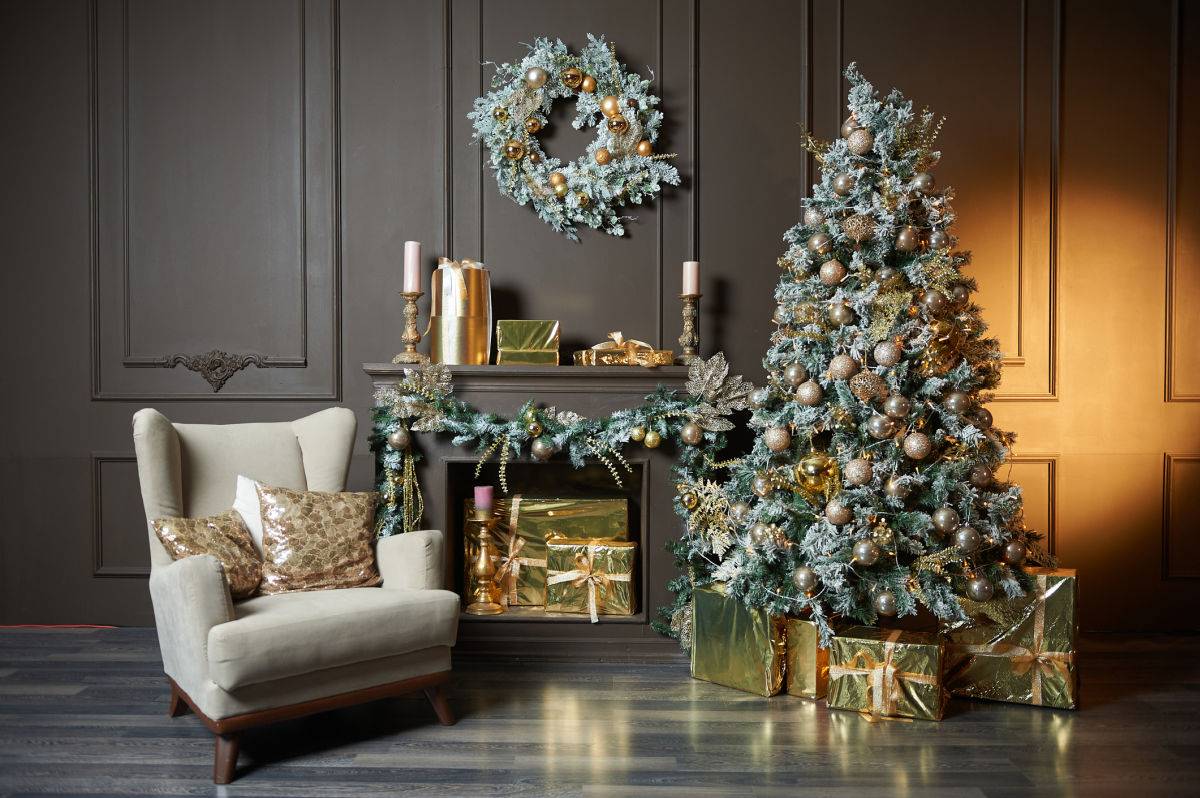 White armchair positioned beside a beautifully decorated Christmas tree with warm lights, textured ornaments and elegant festive styling.