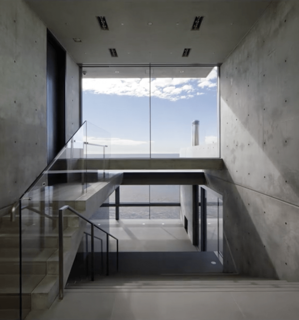 The bare interior of Kanye West’s Malibu mansion, stripped of finishes, looking out toward the ocean through empty window frames.
