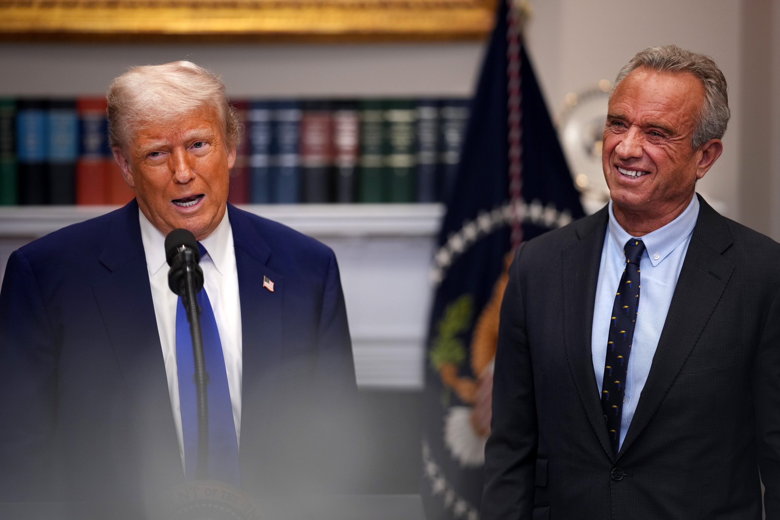 President Donald Trump and US Health Secretary Robert F. Kennedy Jr. standing together during a press briefing.