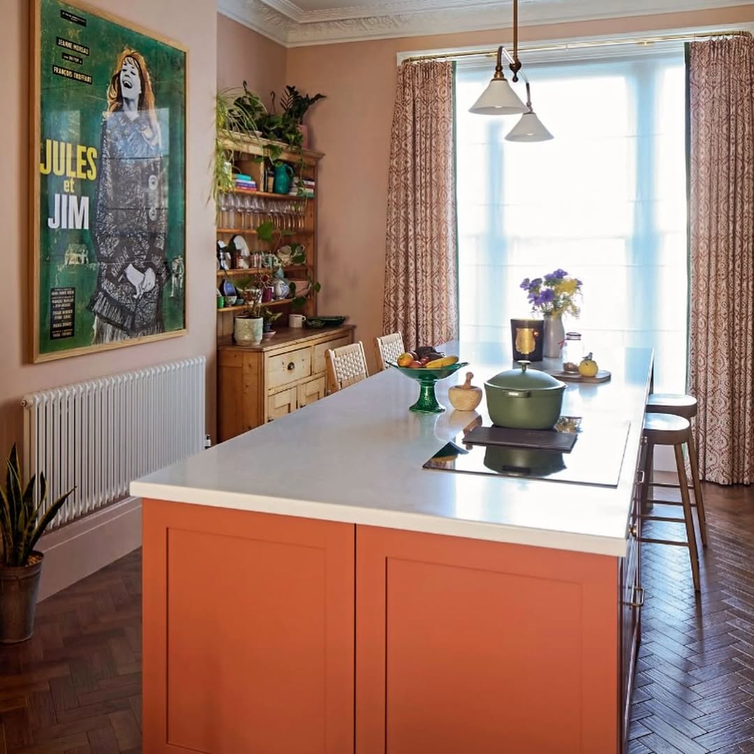 The kitchen in Zoe Ball’s Sussex home, featuring terracotta walls, sage green cabinets, open shelving and abundant plants
