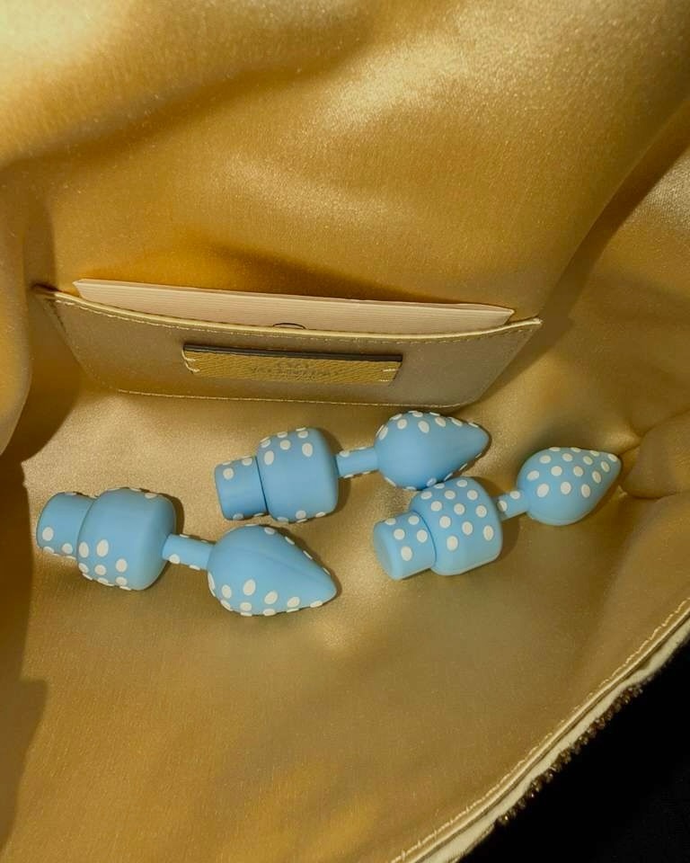 A pile of blue-and-white polka-dotted USB drives shaped like butt plugs, designed as merchandise for Lily Allen’s West End Girl album.