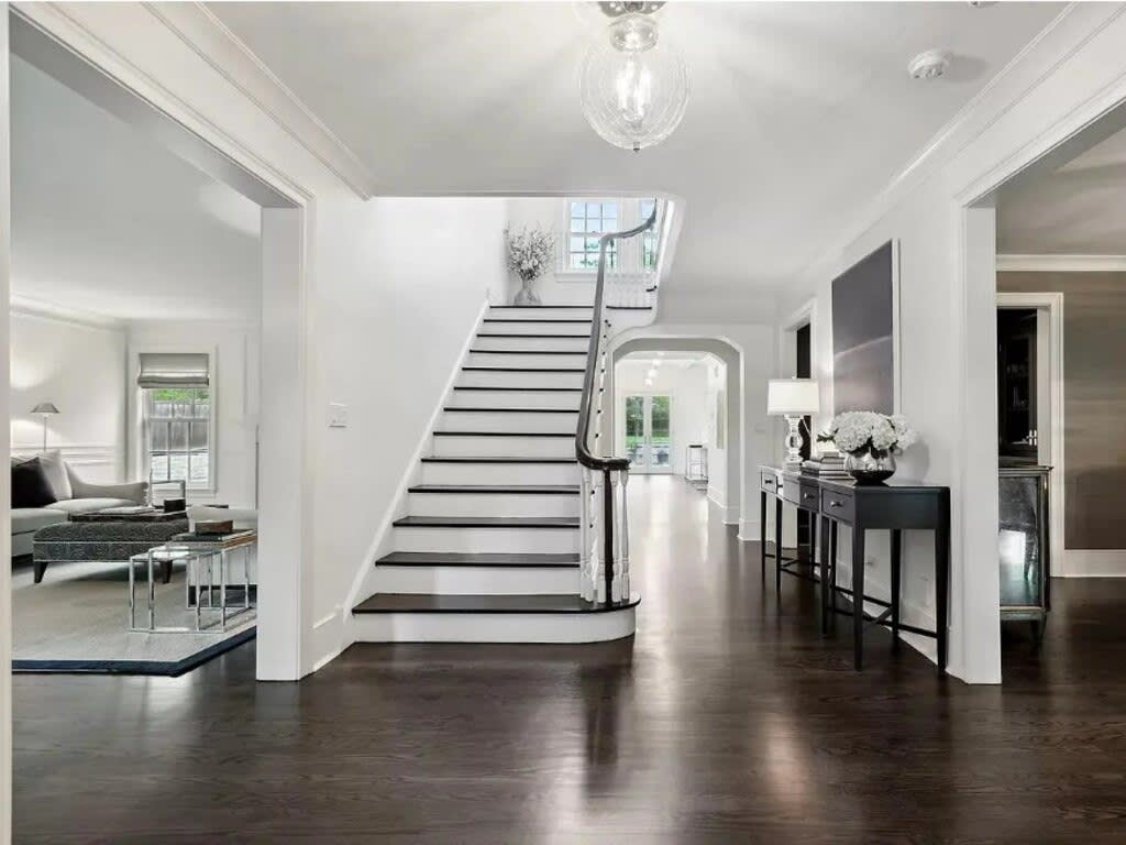 Modern staircase in the Home Alone house, featuring minimalist white and black tones with sleek lines and contemporary design.