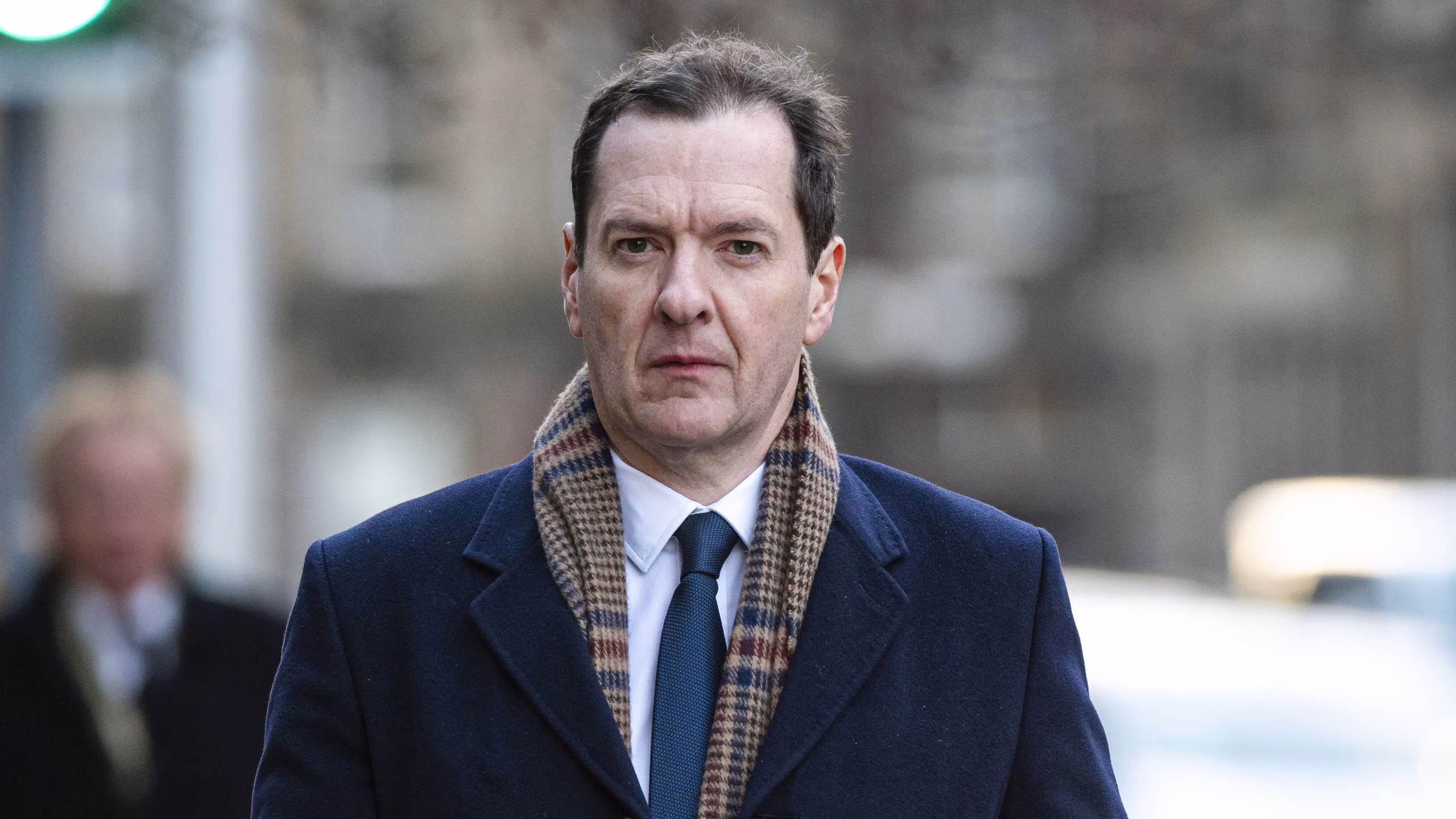 George Osborne walking down the street with a serious expression during a public appearance.