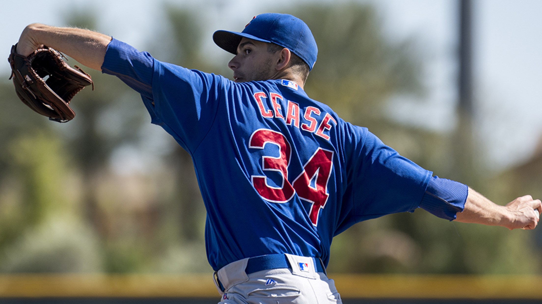 A young Dylan Cease pitching for Chicago, mid-throw with full extension, wearing the classic blue-and-white uniform on the mound.