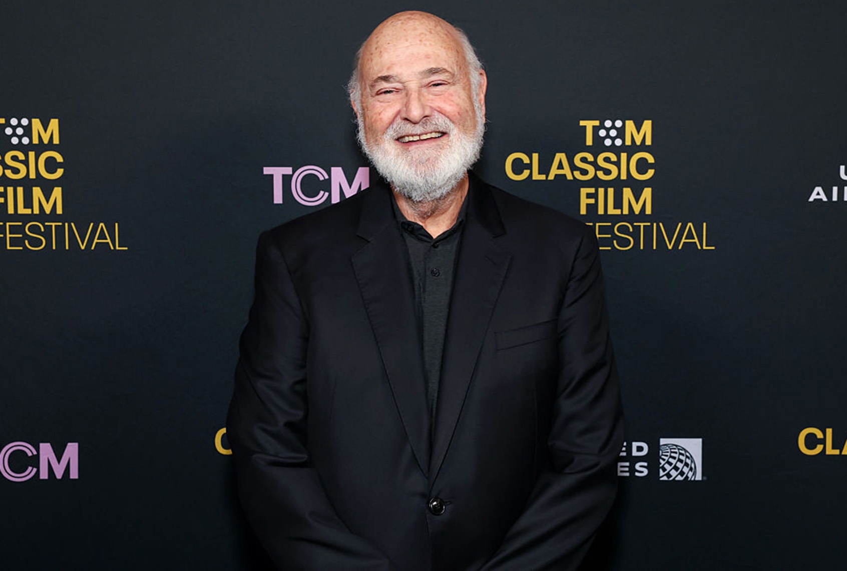 Rob Reiner smiling as he poses on the red carpet