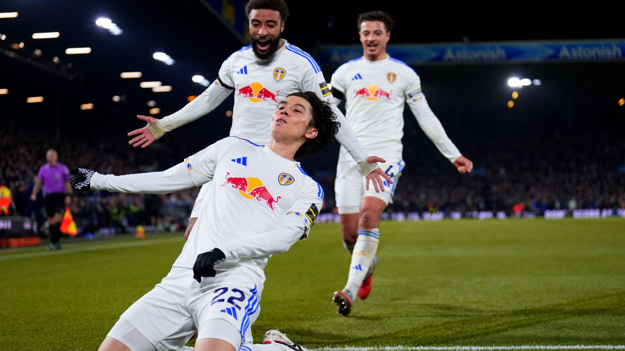 Ao Tanaka celebrating his goal for Leeds United against Chelsea, raising his arms in triumph at Elland Road.