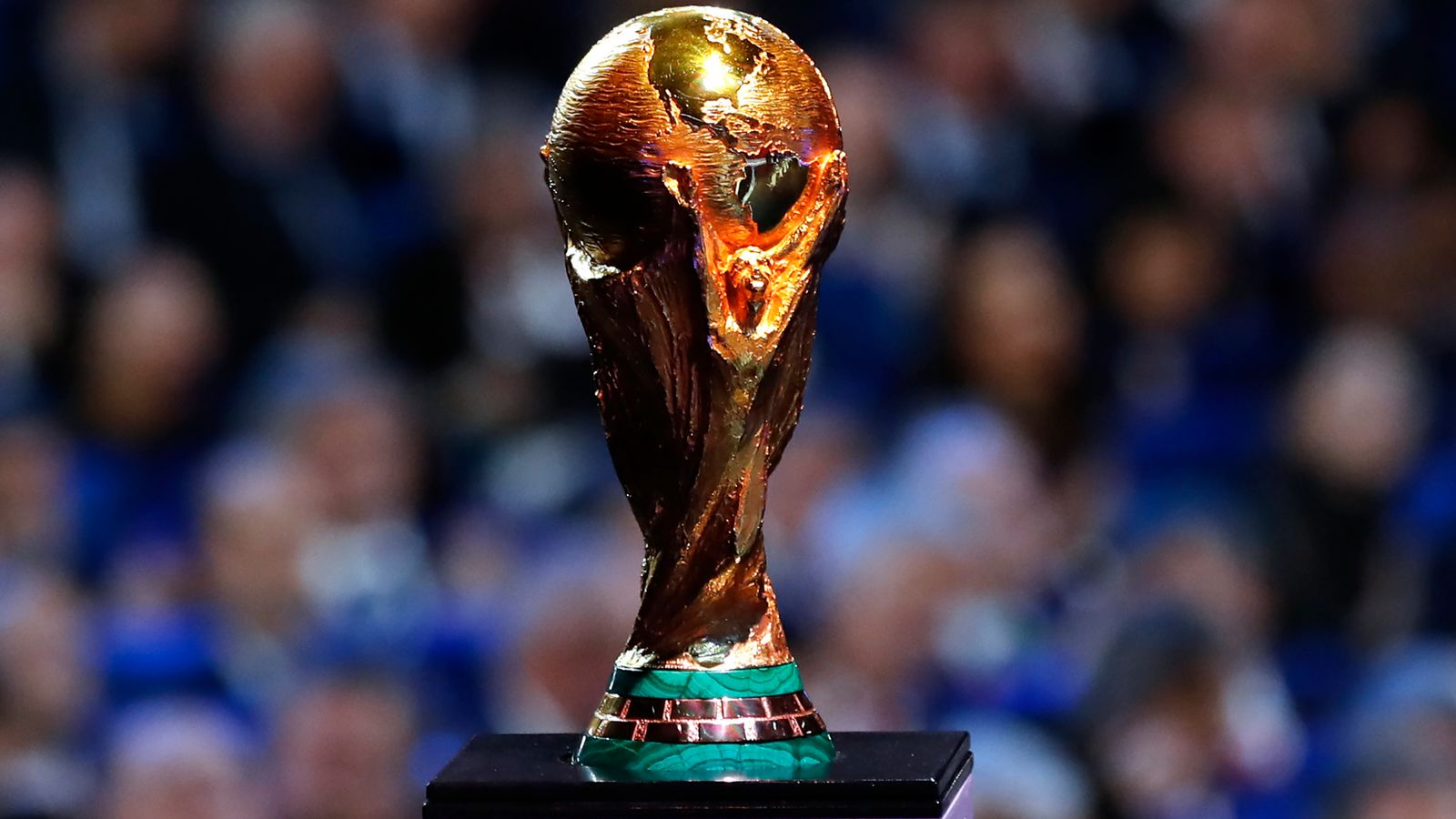 Close-up view of the FIFA World Cup trophy, showing the gold figure and detailed globe design.