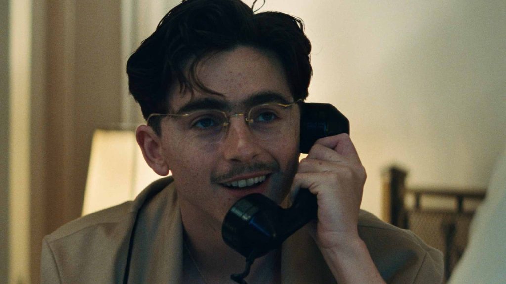 Timothée Chalamet as Marty Supreme, talking on a phone in a pivotal scene from the A24 sports drama.