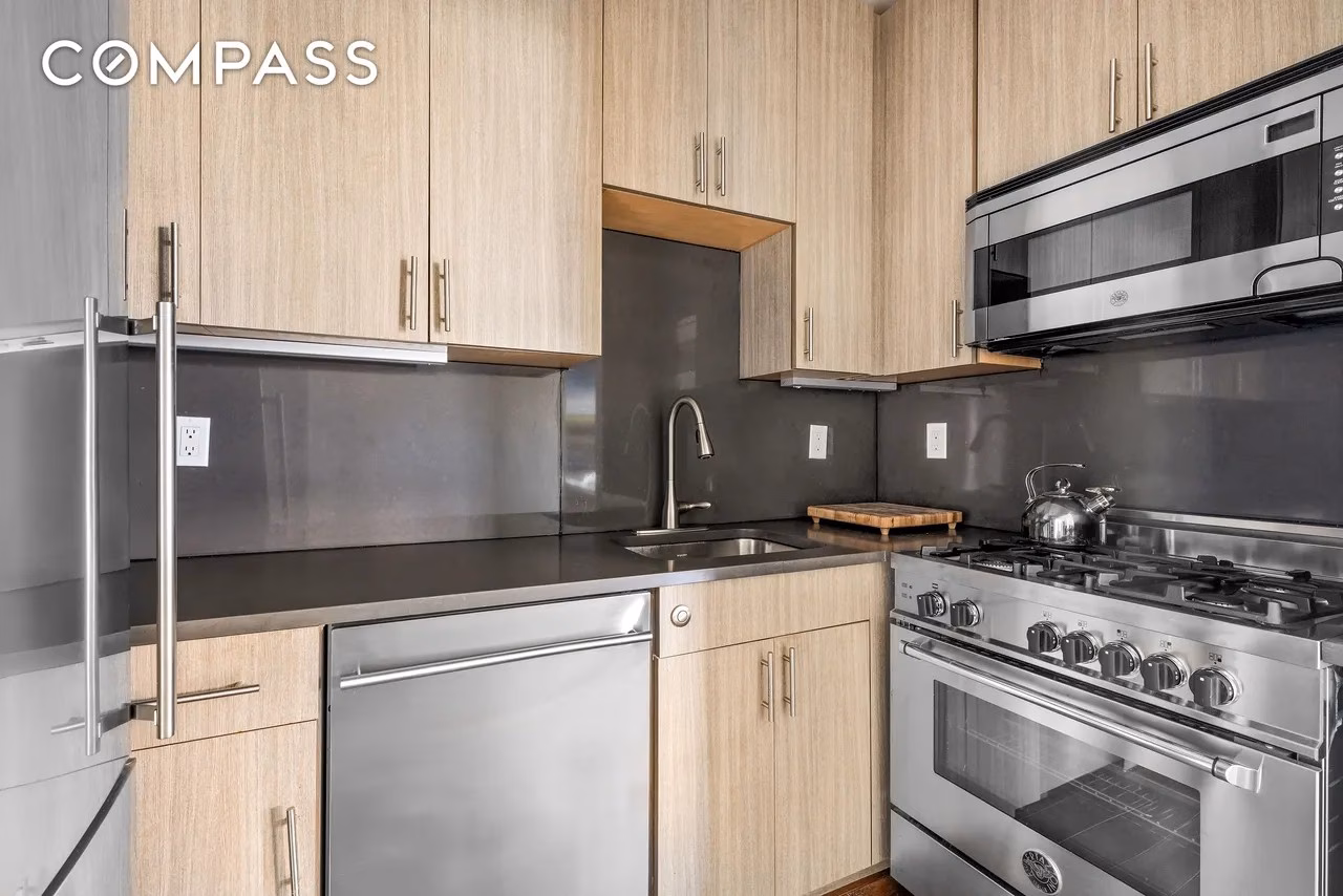 Modern kitchen in Jim Curtis’s Manhattan apartment, featuring sleek cabinetry, stainless steel appliances, and open-concept design.