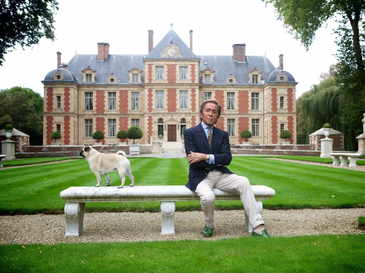 Valentino Garavani seated outside his grand Paris château, showcasing the luxurious lifestyle of the fashion icon.