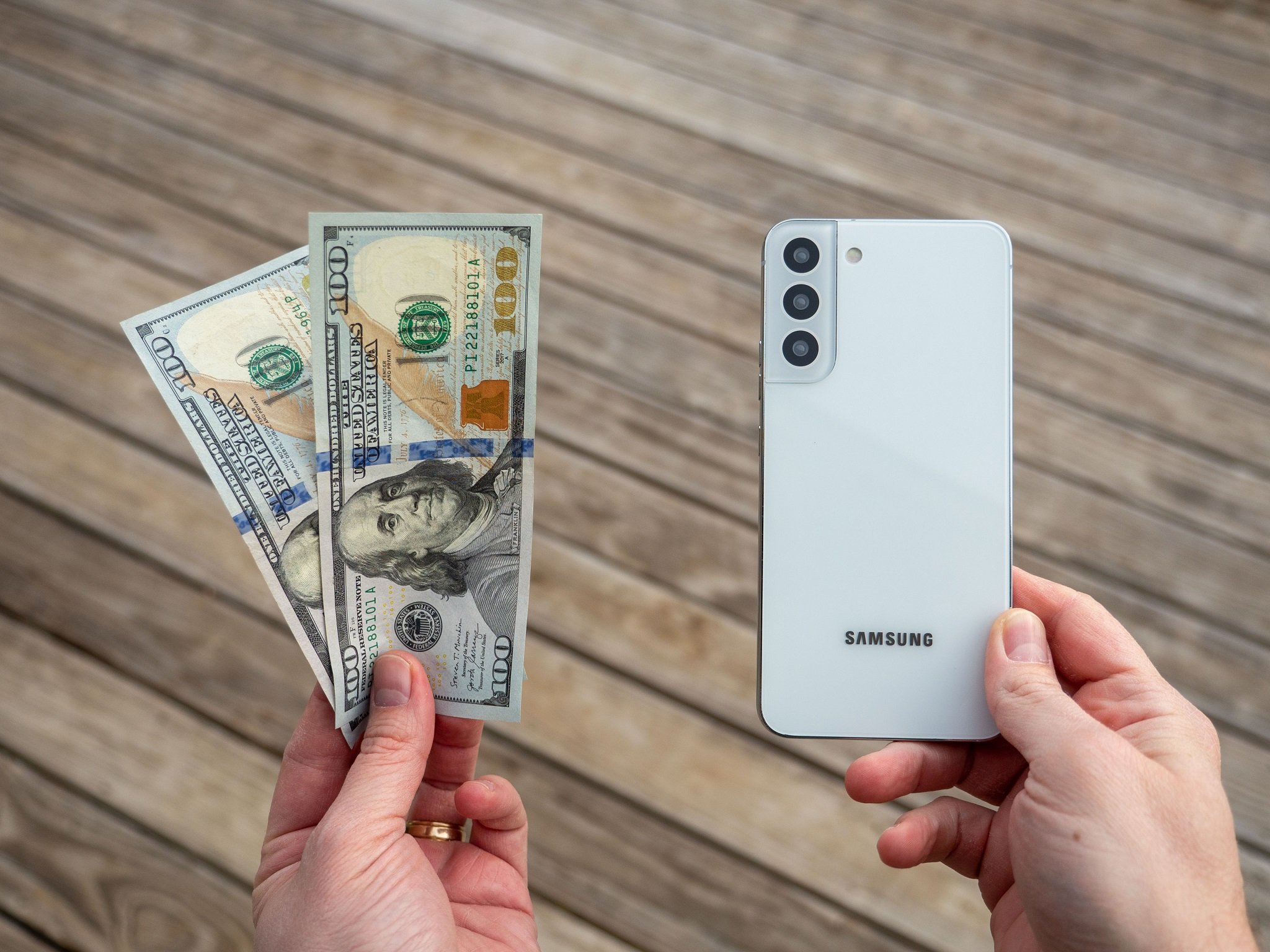 Samsung smartphone beside dollar bills illustrating rising Bill of Materials costs and the impact of AI-driven memory prices on consumer device margins.