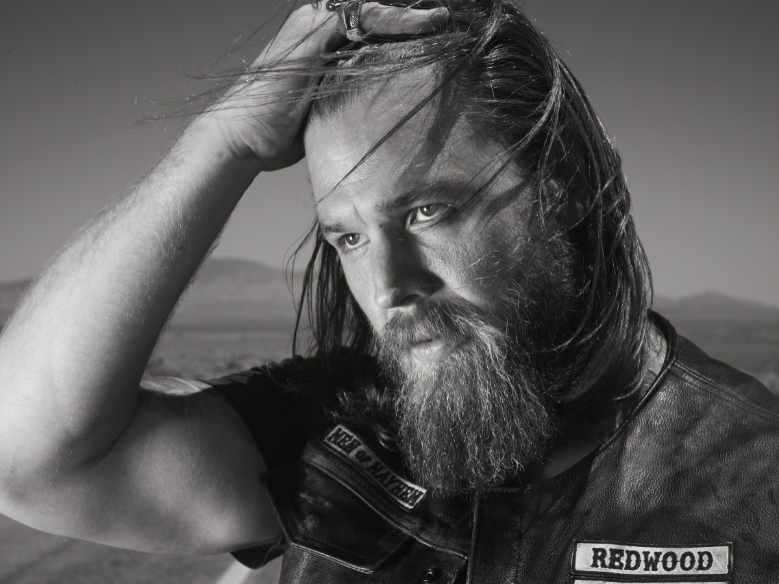 Ryan Hurst as Opie Winston in Sons of Anarchy, wearing a biker vest and sitting on a motorcycle, embodying the tough SAMCRO enforcer.
