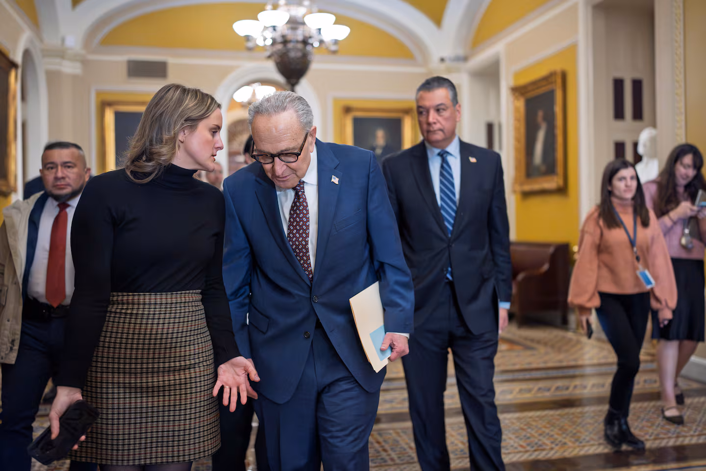 Senate Majority Leader Chuck Schumer walks through the U.S. Capitol alongside aides as lawmakers negotiate over Department of Homeland Security funding ahead of a potential government shutdown.