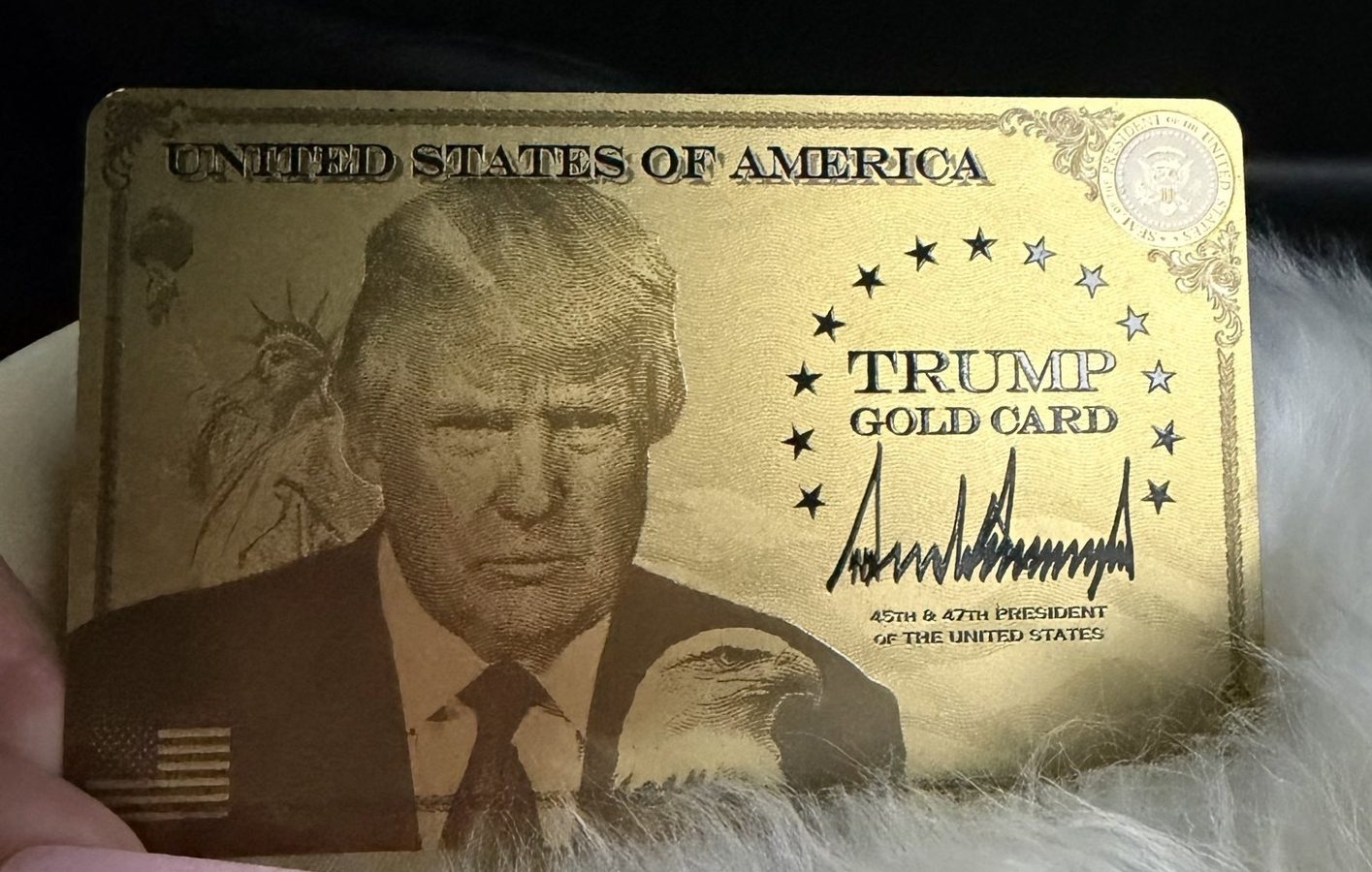 Close-up of Nicki Minaj’s Trump Gold Card, shown at the Trump Accounts Summit, highlighting its gold finish and official insignia.