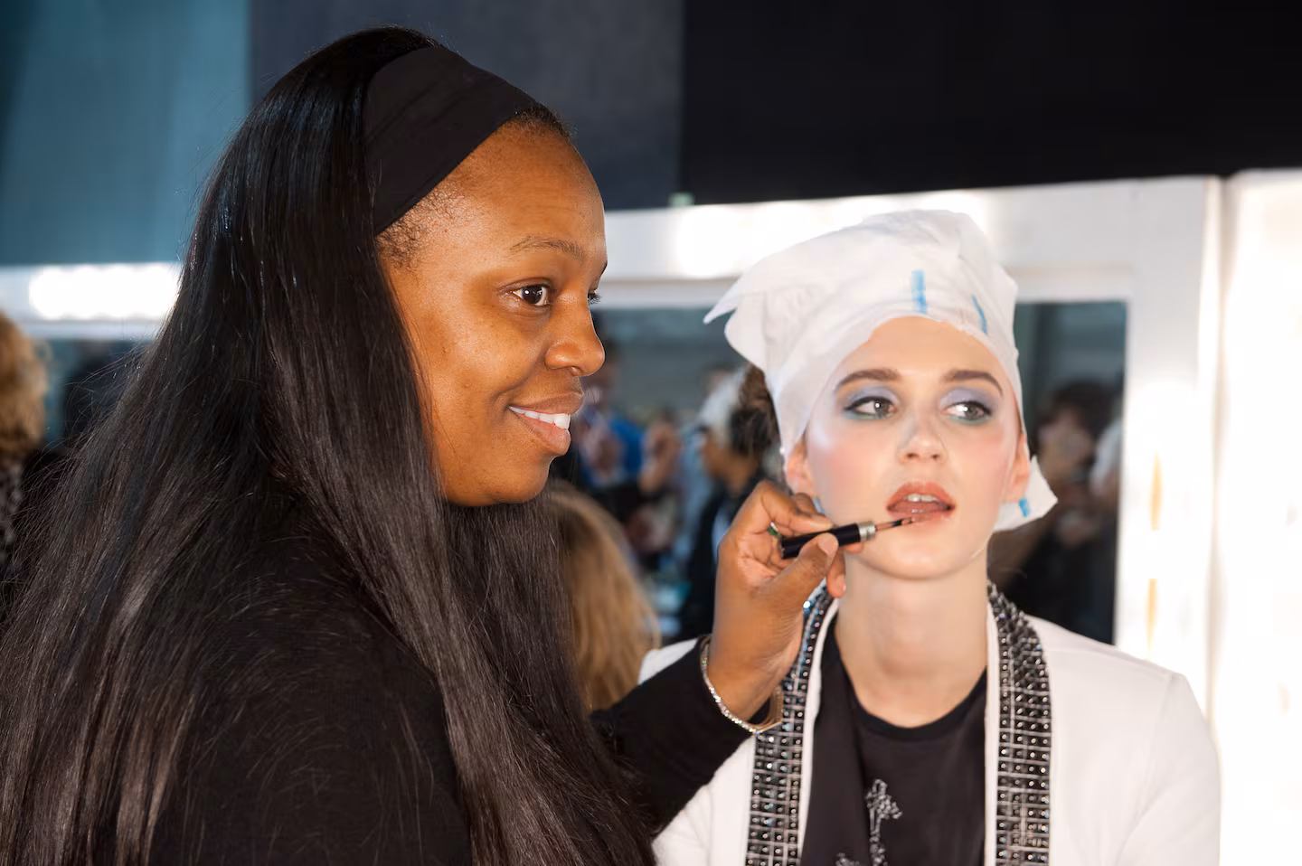 Pat McGrath applying makeup to a client, demonstrating her signature artistry and precision in a professional setting.