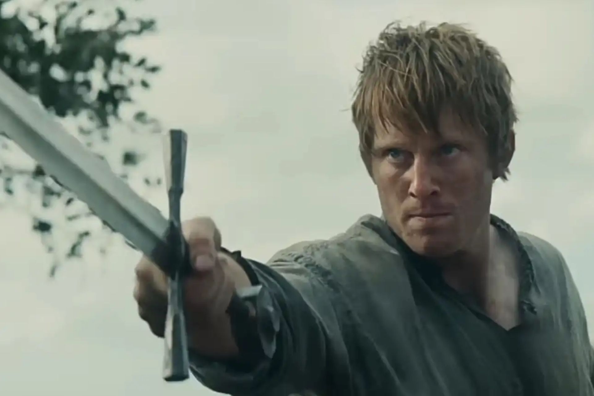 Actor Peter Claffey as Dunc, pointing a sword forward in a dramatic fantasy scene, captured mid-action.