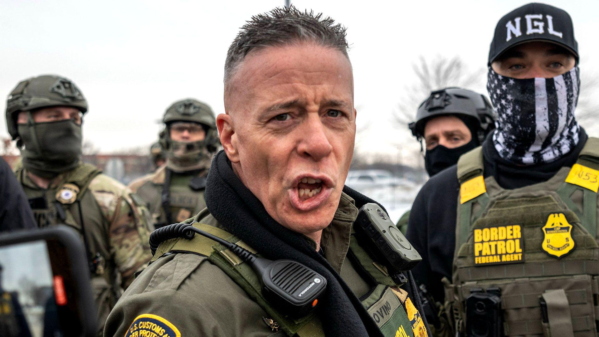 Gregory Bovino shouting angrily into a camera during a Border Patrol operation, wearing his uniform with a tense expression.