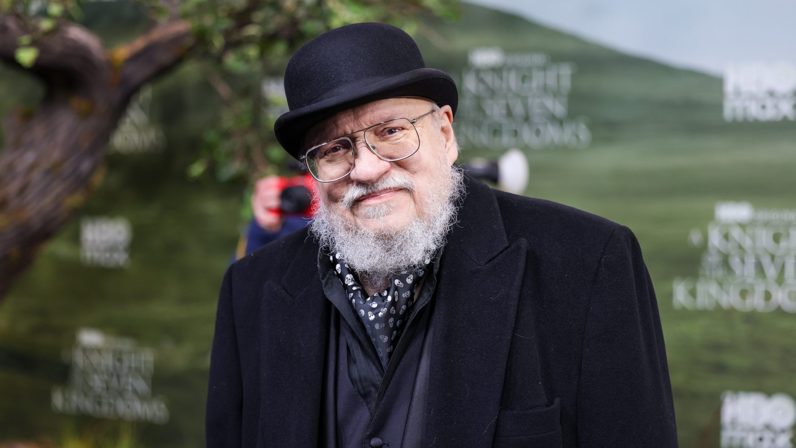 George R.R. Martin smiling on the red carpet at the A Knight of the Seven Kingdoms premiere.