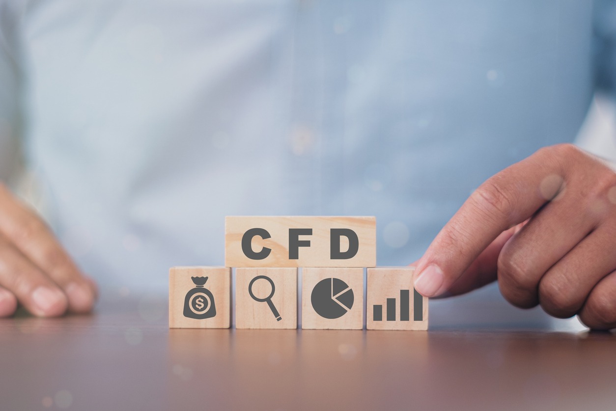 business man puts the wooden cube with success icon cfd. contract for difference financce technology stock market concept.