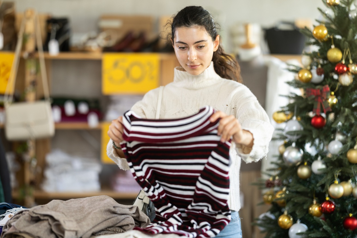 armenian girl near showcase pick out and buying sweater, new year eve