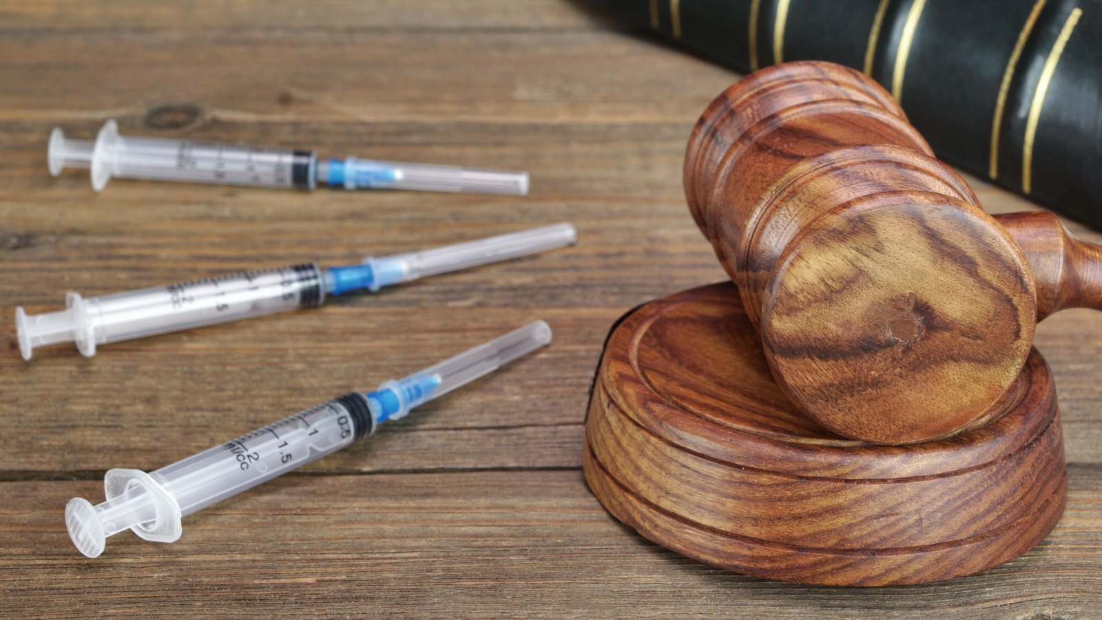A judge’s gavel next to syringes used for lethal injection, symbolizing the costs and complexities of the death penalty.