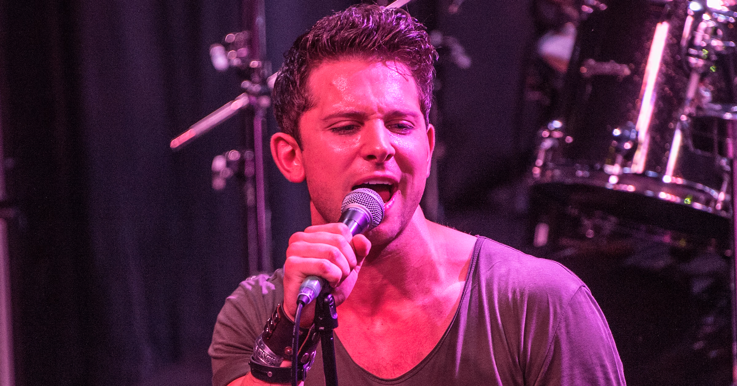 Ross Davidson performing on stage in his early career, showcasing his talent in musical theater and live shows.