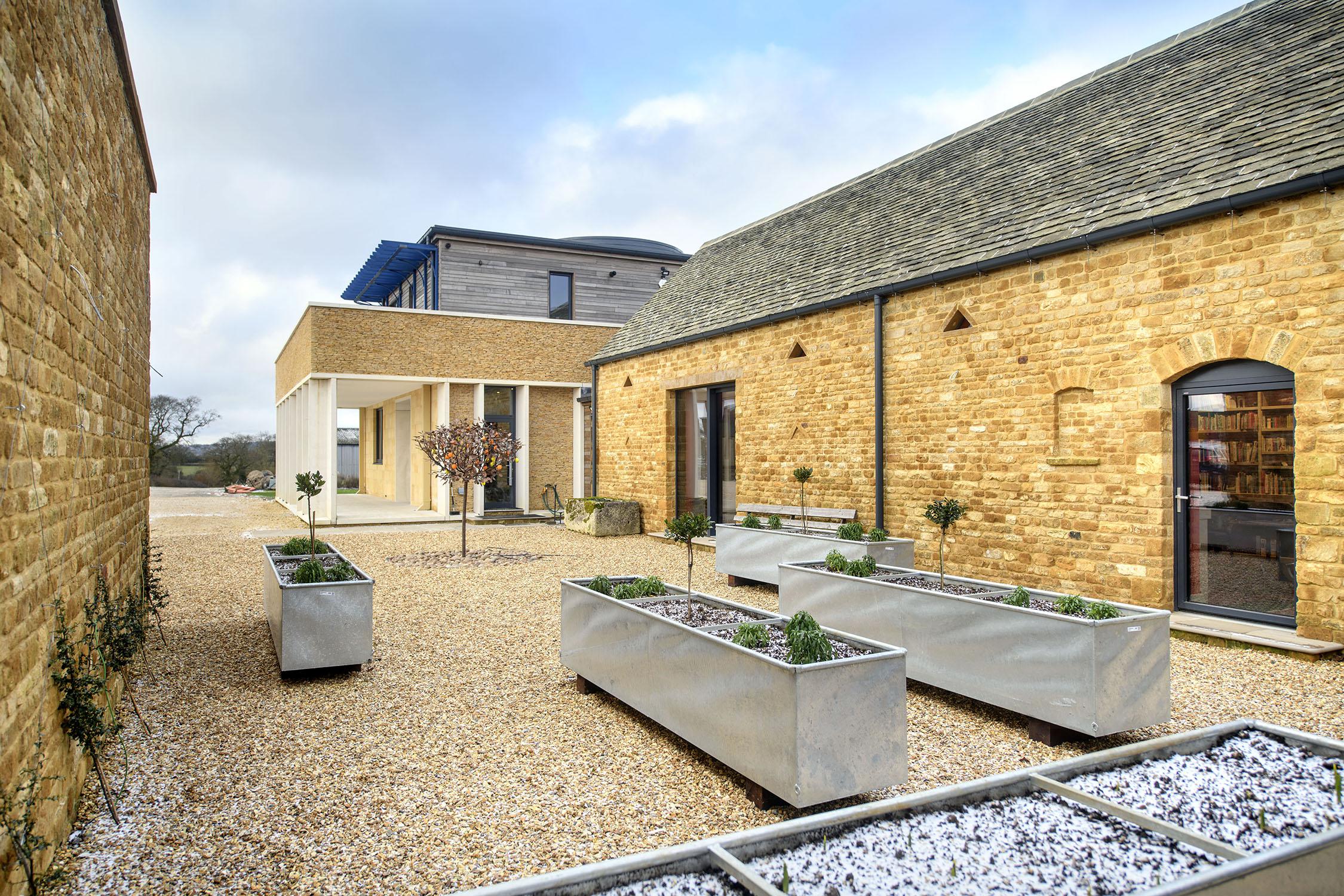 Prue Leith's former Cotswolds estate, a charming countryside home with colorful gardens and traditional stone architecture.