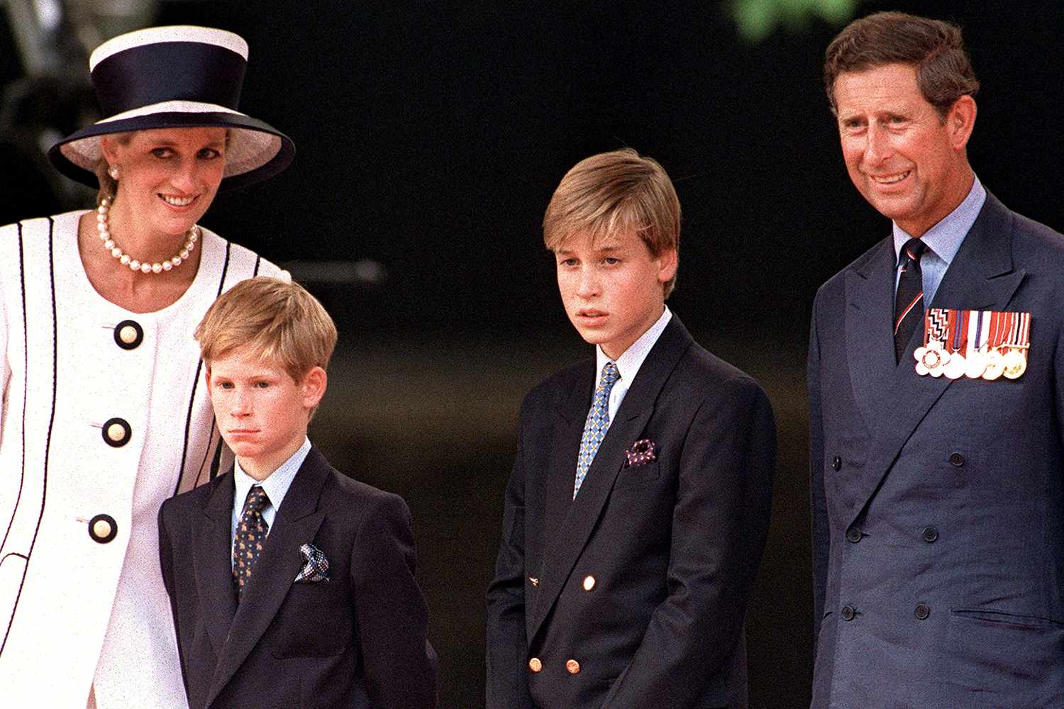 Princess Diana with Prince Charles and their young sons, Prince William and Prince Harry, at a public event.