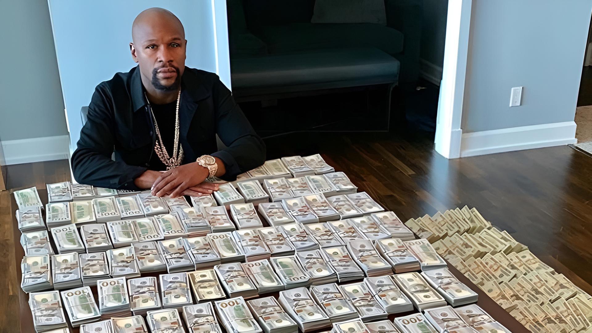 Floyd Mayweather seated at a table covered in stacks of cash, reflecting his long-standing “Money” Mayweather persona.